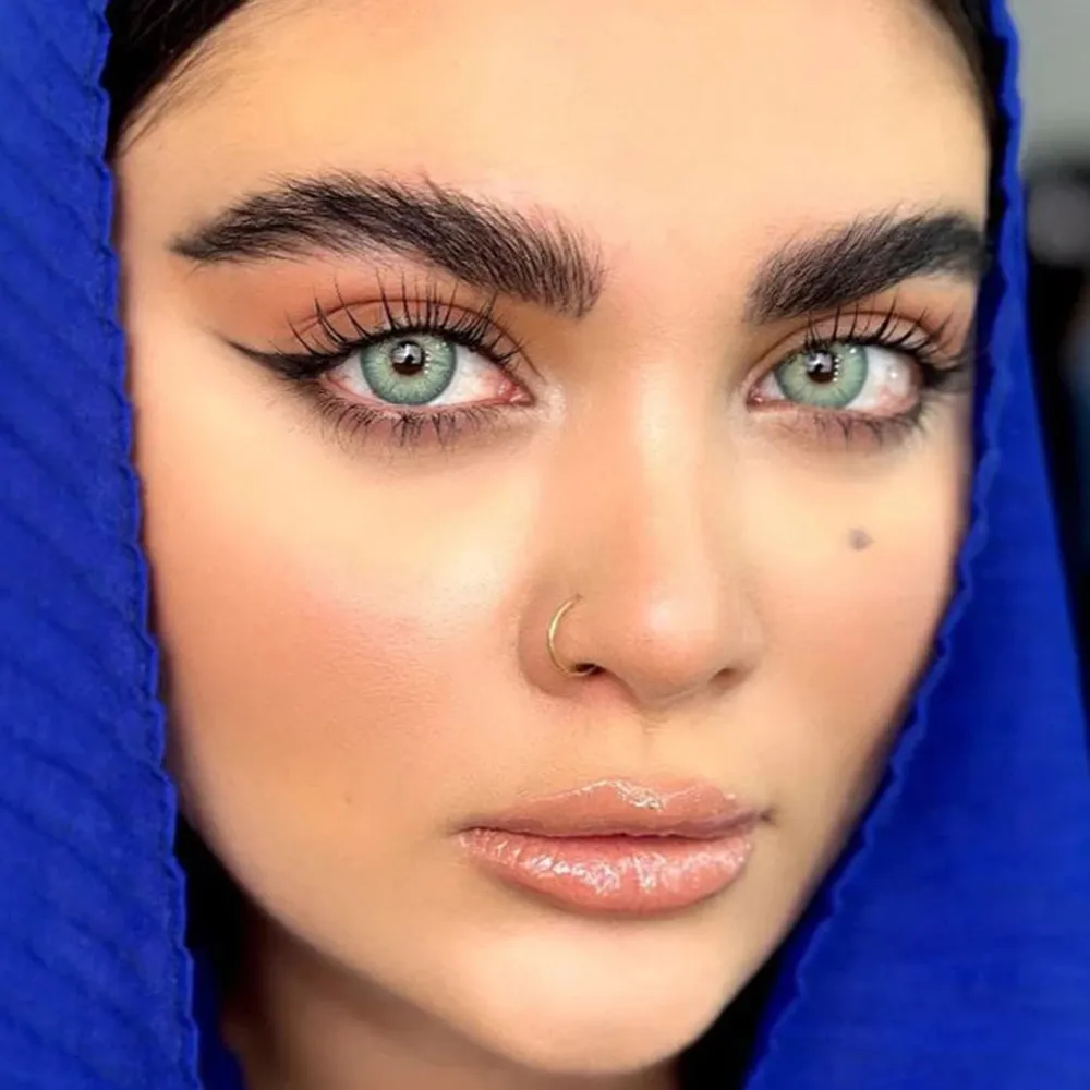 لنز رنگی سبز آبی دور محو باربی بلو یونیک روی چشم قهوه ای