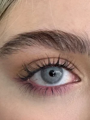 لنز رنگی طوسی خاکستری تیله ای کارنلین یونیک روی چشم قهوه ای